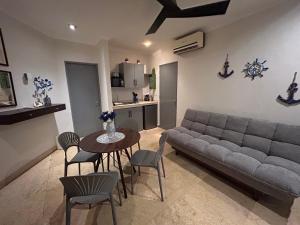 a living room with a couch and a table and chairs at Blue angel 24 in Playa del Carmen