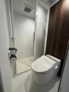 a white bathroom with a toilet and a shower at The Bunkhouse Hakuba by Mr T in Hakuba