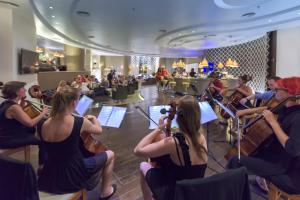 een groep mensen die muziek spelen in een orkest bij Olympic Palace Hotel in Ixia