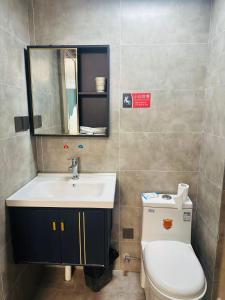 a bathroom with a sink and a toilet and a mirror at Chongqing Justom Family Serviced Apartments 4 in Chongqing +57 photos