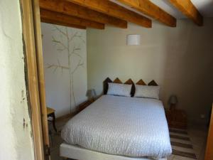 um quarto com uma cama branca num quarto em Maison d'Hôtes Lou Cliou em Cliousclat