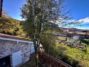 a tree next to a house with a yard at Ferme Ihartzetako in Ascain +11 photos