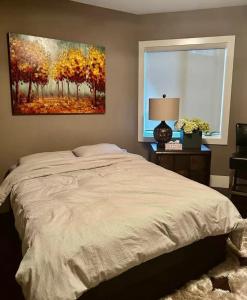 a bedroom with a bed and a painting on the wall at White Rock Joy Inn in White Rock