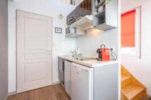 オーディエルヌにあるAppartement duplex vue merの白いキャビネットと白いドア付きのキッチン
