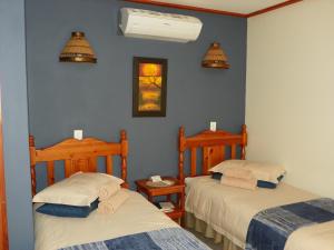 2 letti in una camera con pareti blu di At-Neli Guesthouse a Christiana