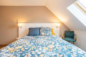 オーディエルヌにあるAppartement duplex vue merの青い掛け布団と椅子が置かれたベッドのある寝室