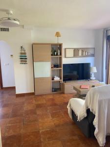 een slaapkamer met een bed, een tafel en een bank bij Beautiful apartment with gardens - sea and mountain views in Isla Plana