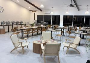 un restaurant avec des tables et des chaises dans une salle dans l'établissement Borneo Nature Lodge 2, à Kinabatangan
