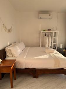 a bedroom with two beds and a wooden table at Keeree Farm คีรีฟาร์ม ดอยช้าง ที่พักบนดอยช้าง in Ban Huai Khai