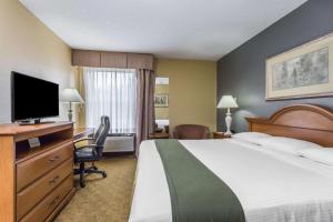a hotel room with a bed and a flat screen tv at Days Inn by Wyndham Selma in Selma