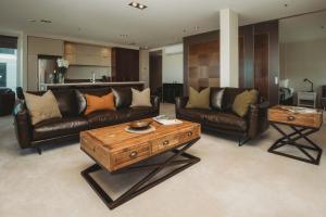 a living room with leather couches and a coffee table at Liardett Penthouse - Inner city accommodation in New Plymouth