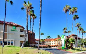 a hotel with palm trees in front of a street at Holiday Inn Express La Mesa Near SDSU by IHG in La Mesa