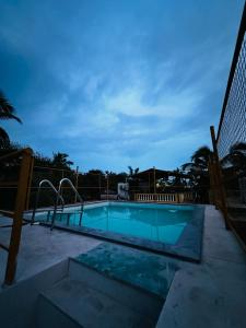 卡兰古特peppy Beach Inn Goa的夜间游泳池,带围栏