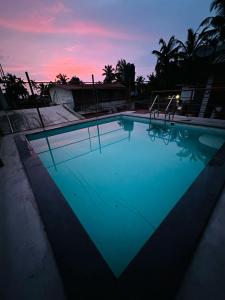 卡兰古特peppy Beach Inn Goa的一座享有日落美景的大型游泳池