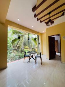 卡兰古特peppy Beach Inn Goa的一间带桌椅和阳台的餐厅 更多46张照片