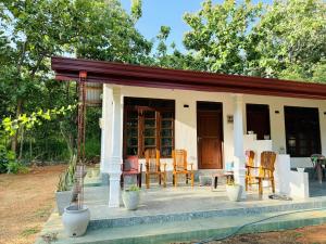 a house with a porch with chairs and a table at Sigiri Thaniya Villa in Sigiriya