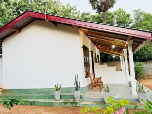a white house with a red roof at Sigiri Thaniya Villa in Sigiriya