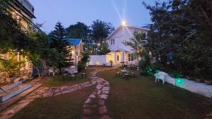 a yard with tables and chairs in front of a house at DM Farms Morni Hills Panchkula in Morni