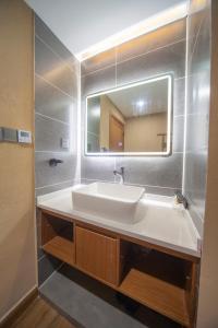 a bathroom with a sink and a mirror at Fenghuang Sulv Yunzhu River View Homestay in Fenghuang