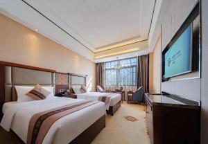 una habitación de hotel con dos camas y un televisor de pantalla plana en The Sky Gate Hotel, en Zhangjiajie