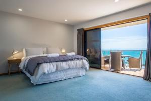 une chambre avec un lit et une vue sur l'océan dans l'établissement Waterfront On Woolcombe - 4BR holiday apartment, à New Plymouth