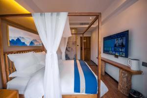 a bedroom with a canopy bed with white pillows at Fenghuang Sulv Yunzhu River View Homestay in Fenghuang