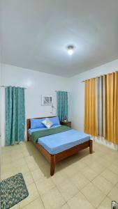 DauisにあるRoyal Palm 3のベッドルーム1室(青いシーツとカーテン付きのベッド1台付)