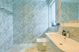 a white bathroom with a sink and a mirror at Aqua Resort Aonang Krabi in Ao Nang Beach +42 photos