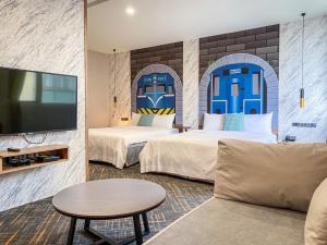 a hotel room with two beds and a tv at Hotel Jiji Plus in Ch'ai-ch'iao-t'ou