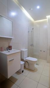 Un baño con inodoro, lavabo y ducha. en URBAN WHITE Elya 1, en Beni Mellal