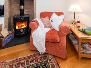 a living room with a chair and a fireplace at Ty Menyn in Mathry