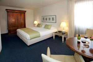 a hotel room with a bed and a table with a table at Bed and Breakfast Holter in Enschede