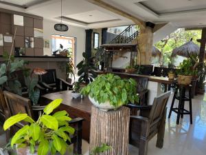 ein Esszimmer mit einem Tisch und vielen Pflanzen in der Unterkunft Tendan Residence Hotel in Legian