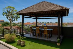 einen Pavillon mit einem Tisch und Stühlen auf einer Terrasse in der Unterkunft Tendan Residence Hotel in Legian + 3 Fotos
