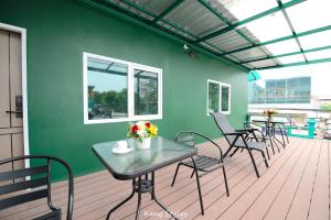 a patio with a table and chairs and a green wall at GL Sport Club Serviced Residence & Hotel in Bangkok