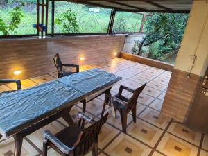 a patio with a table and chairs and a large window at Bungalow in Lonavala