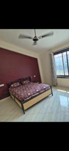 una camera da letto con un letto e un ventilatore a soffitto di Bungalow a Lonavala
