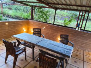 a table and chairs on a screened in porch at Bungalow in Lonavala