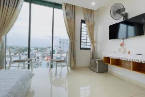 a bedroom with a bed and a tv on a wall at Ruby Star Hotel Apartment in Vung Tau