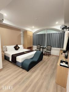 a hotel room with a large bed and a desk at One Villa Hotel 6 in Long Biên