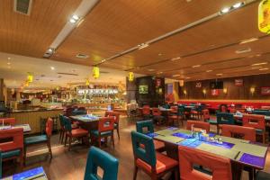 um restaurante com mesas, cadeiras e um bar em Changsha Xiaoxiang Huatian Hotel em Changsha