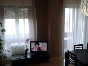 ミラノにあるMilan Certosa 3 bedroomsの窓のある部屋(テーブルに座ったテレビ付)