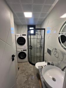 a bathroom with a sink and a washing machine at Mirşah Suit in Bezkesen