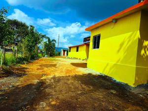 a yellow building next to a dirt road at Sunrise Resort in Araku