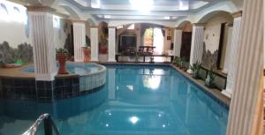 a large swimming pool in a large house with a pool at Villa Promentilla in Inosloban