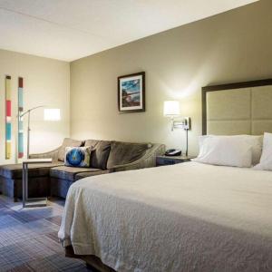a hotel room with a bed and a couch at Hampton Inn Somerset in Somerset