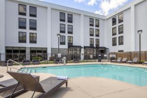 a swimming pool with chairs and a building at Hampton Inn New Bern in New Bern