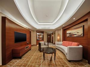 a living room with a couch and a tv at Hilton Hefei in Hefei