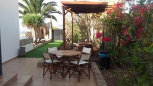 - une terrasse avec une table, des chaises et des fleurs dans l'établissement LUXURY VILLA Ocean Views, à Candelaria
