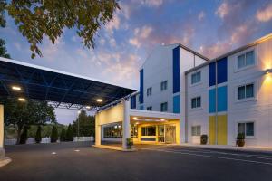 a large white building with a blue roof at Days Inn by Wyndham Penn State in State College